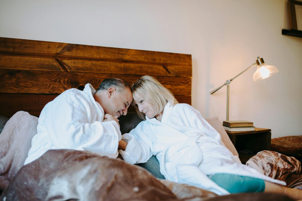 A loving senior couple enjoying a peaceful moment together in their cozy bedroom.